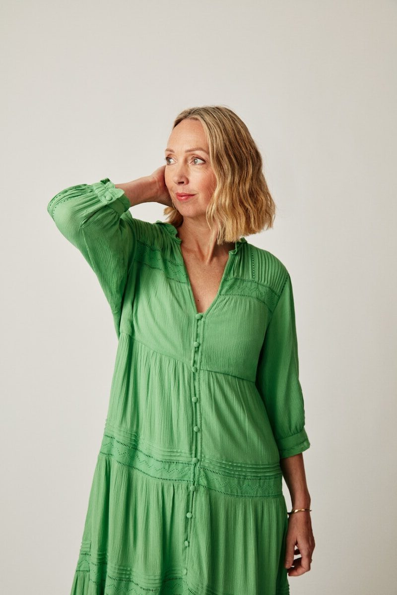 a woman in a green dress posing for a picture